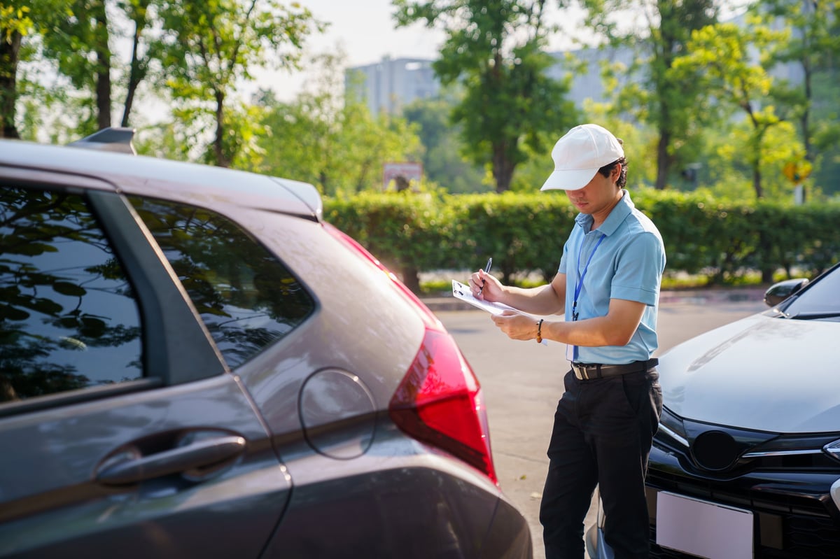 Insurance officer evaluating auto insurance claims on-site